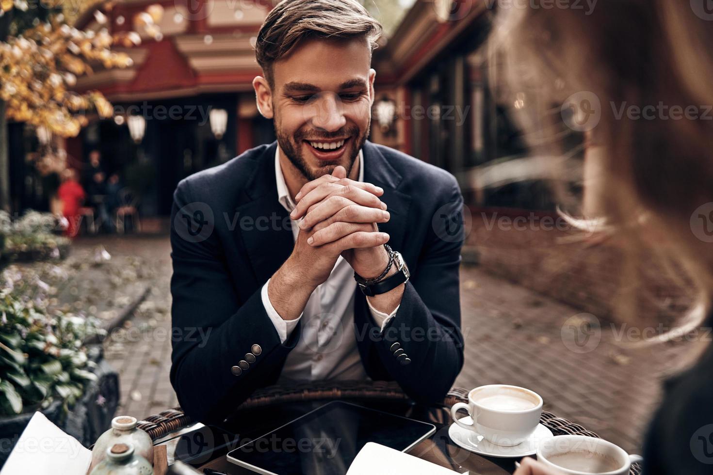 lavoro colloquio. bello giovane uomo nel inteligente casuale indossare sorridente mentre avendo un' conversazione con giovane donna nel ristorante foto