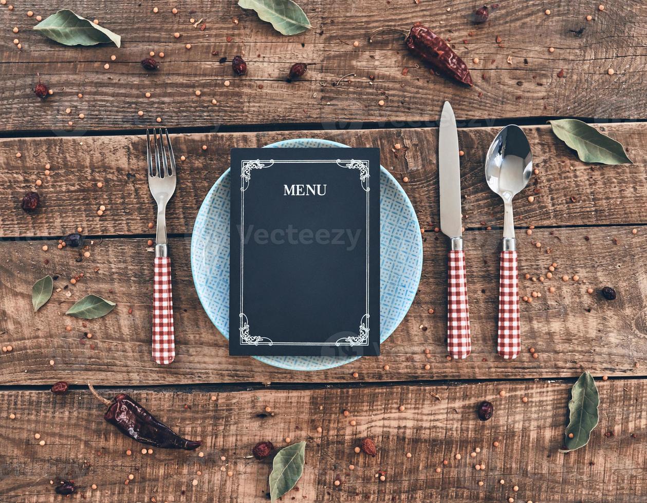 tempo per pranzo alto angolo tiro di vuoto piatto, forchetta, cucchiaio, coltello e chiuso menù dire bugie su rustico tavolo foto