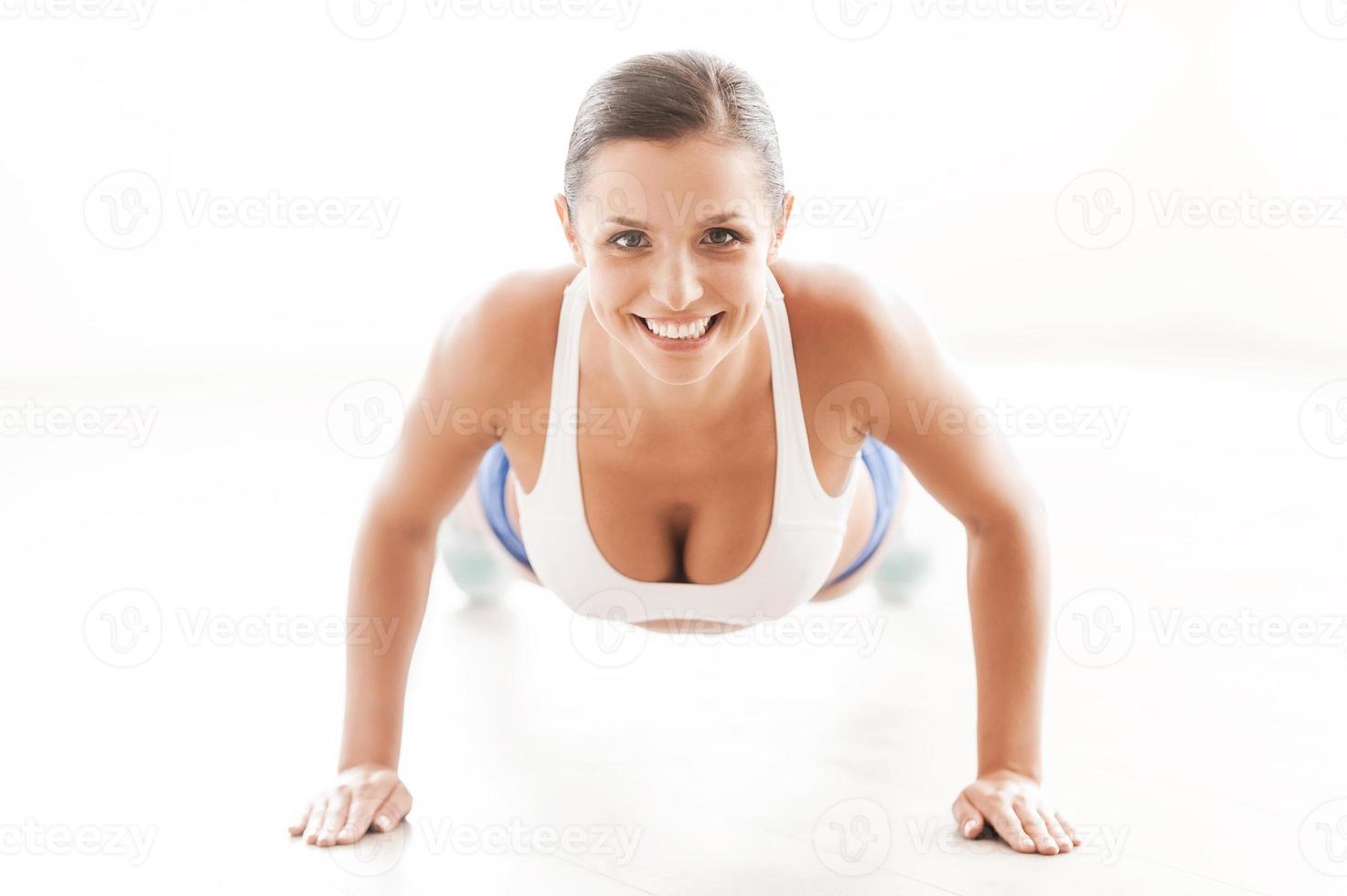 donna esercizio. davanti Visualizza di bellissimo giovane donna nel gli sport capi di abbigliamento fare sollevamento foto
