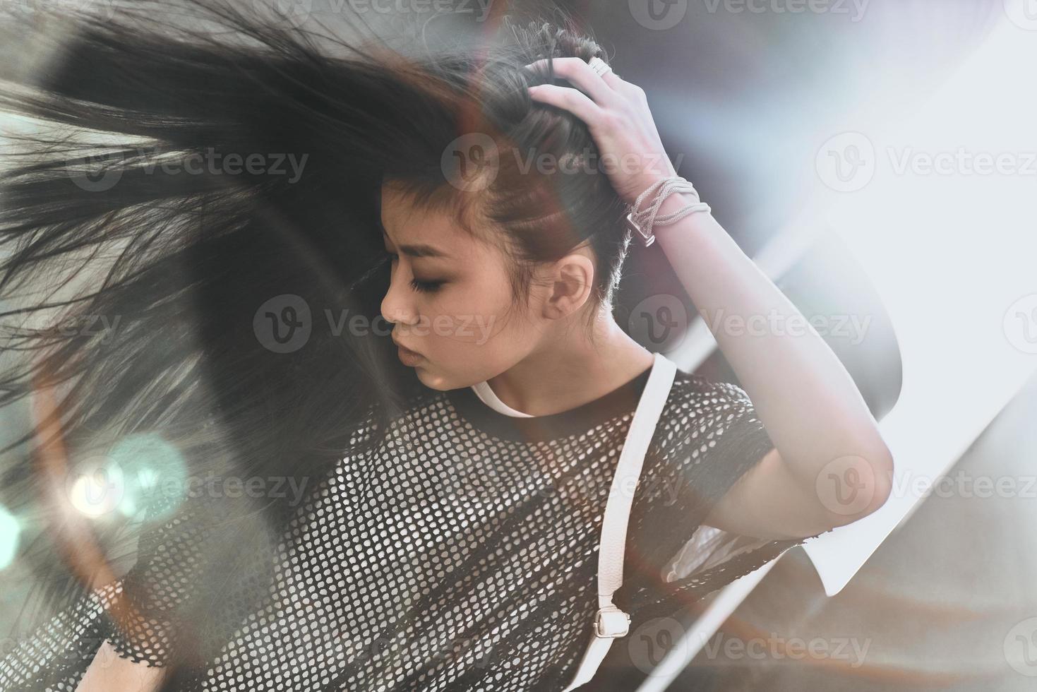 bellissima bellezza. attraente giovane donna nel casuale indossare conservazione mano nel capelli mentre in posa all'aperto foto