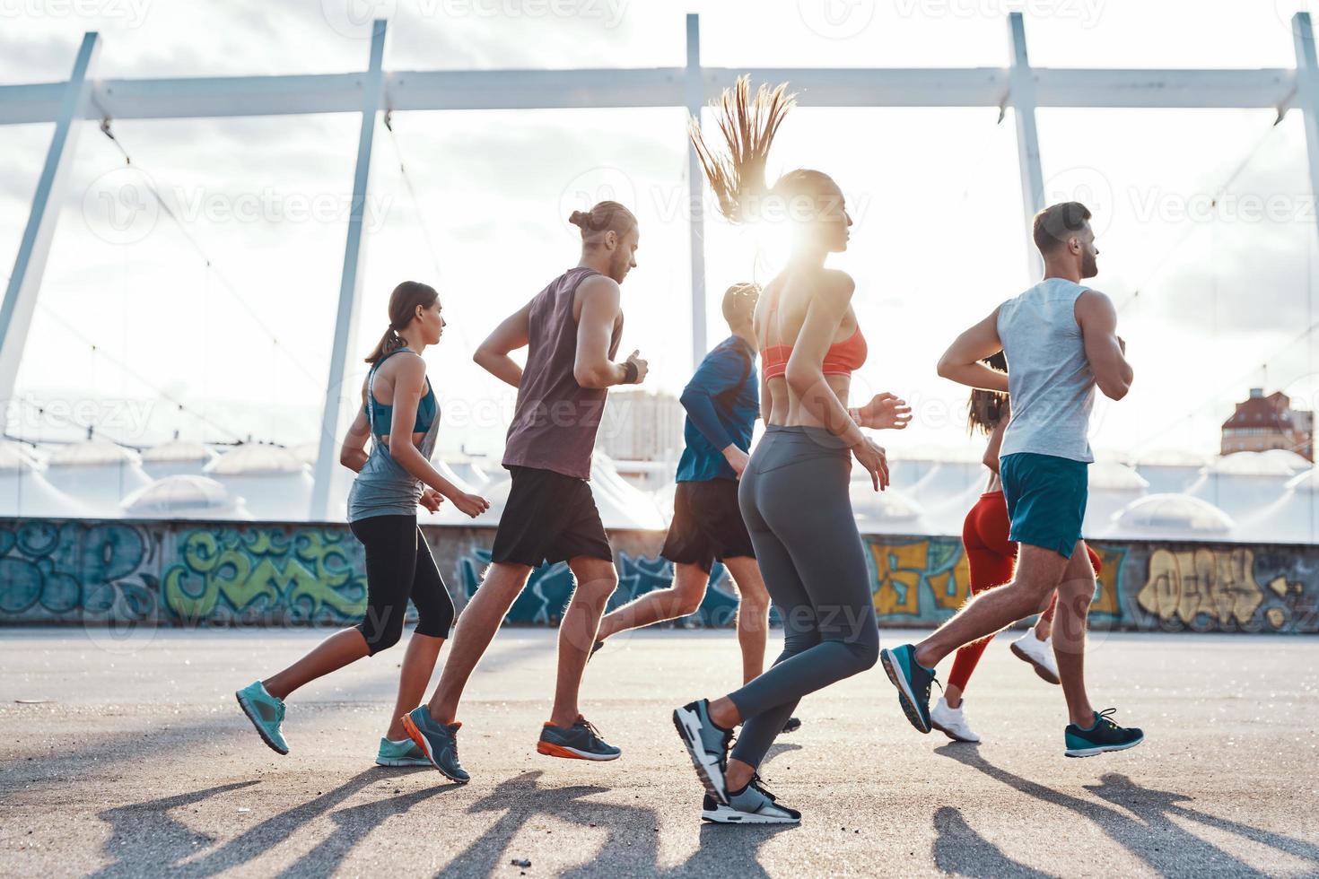 pieno lunghezza di giovane persone nel gli sport capi di abbigliamento jogging all'aperto foto