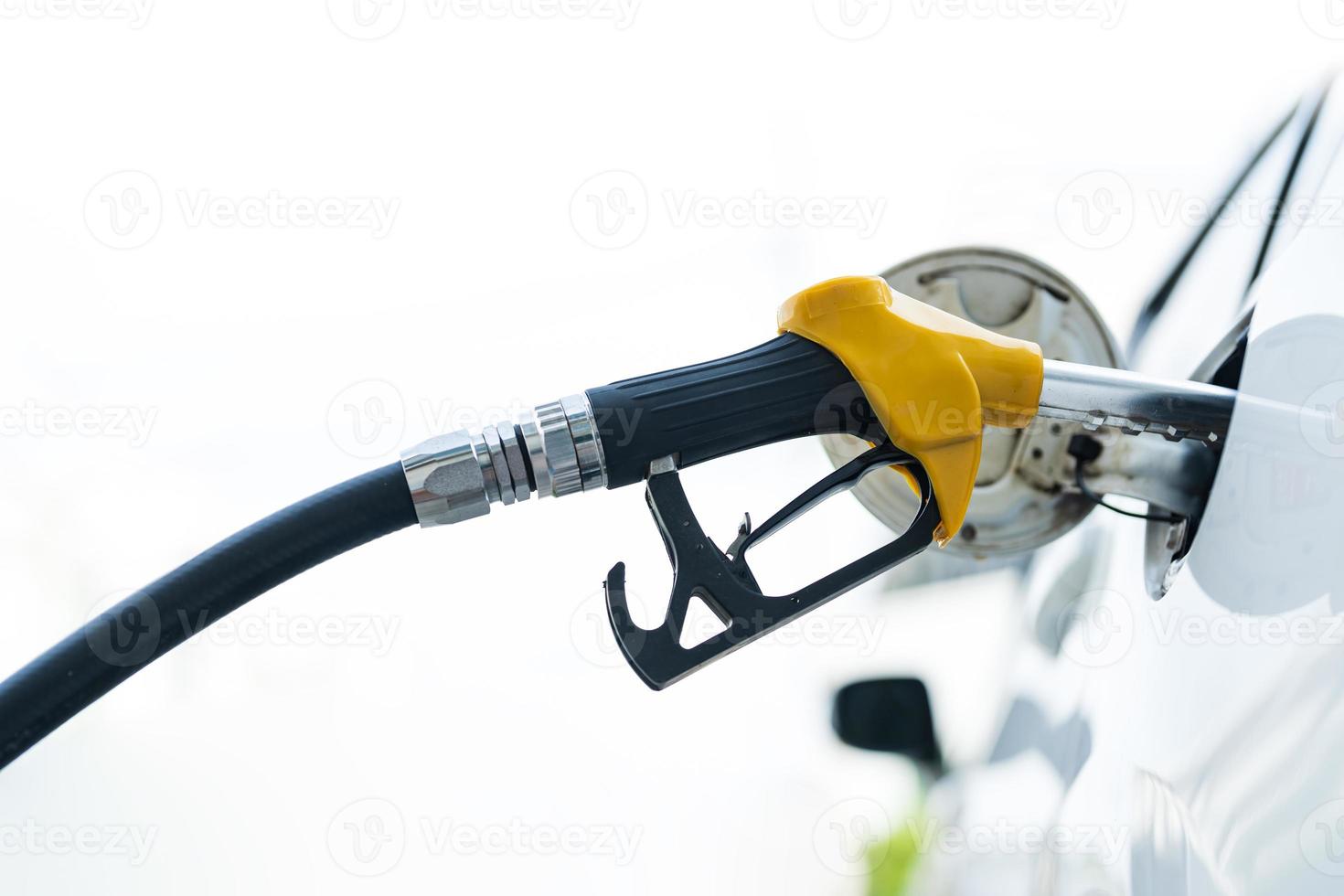 Riempimento auto con gas carburante a stazione pompa foto