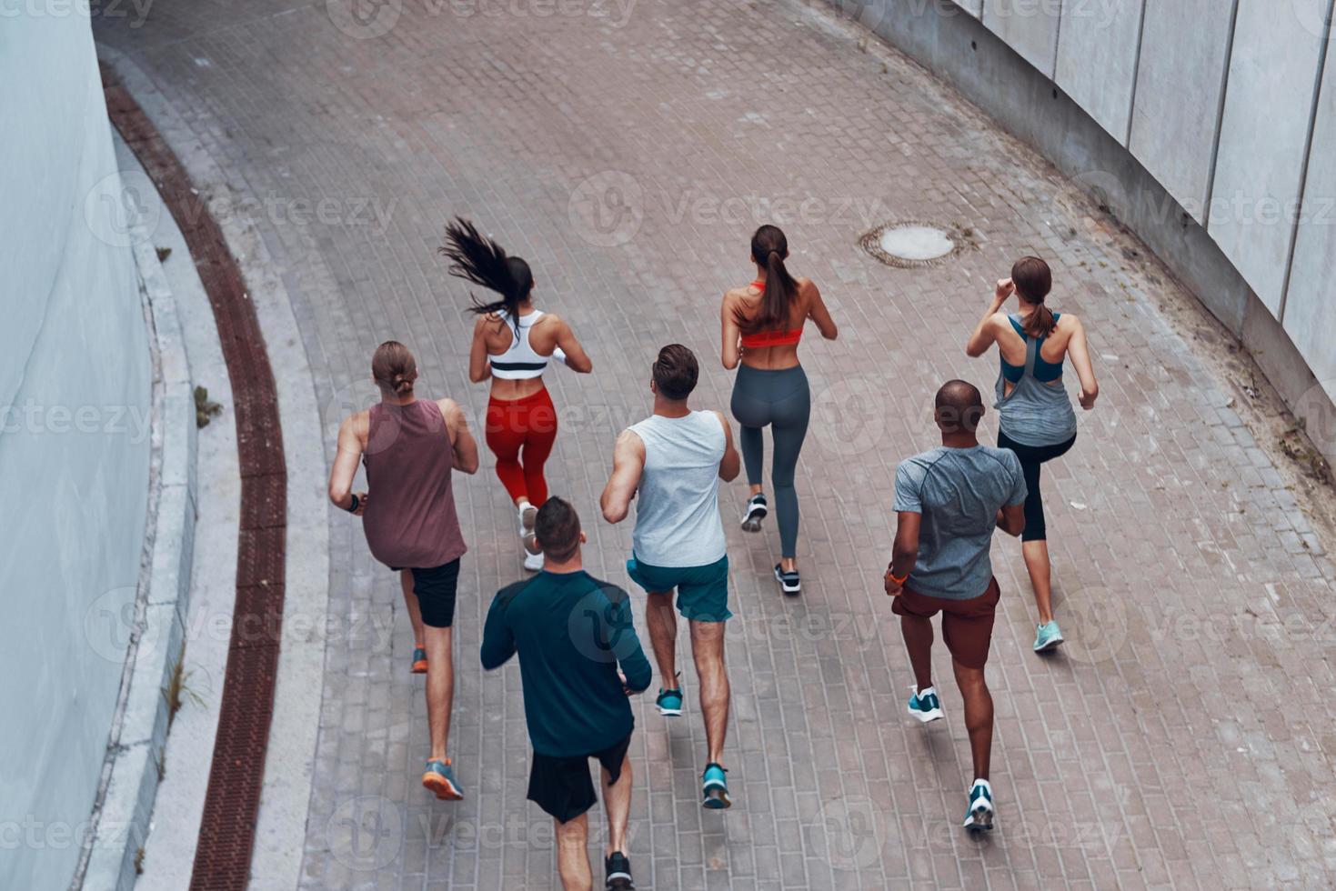 superiore Visualizza di giovane persone nel gli sport capi di abbigliamento jogging mentre esercizio all'aperto foto