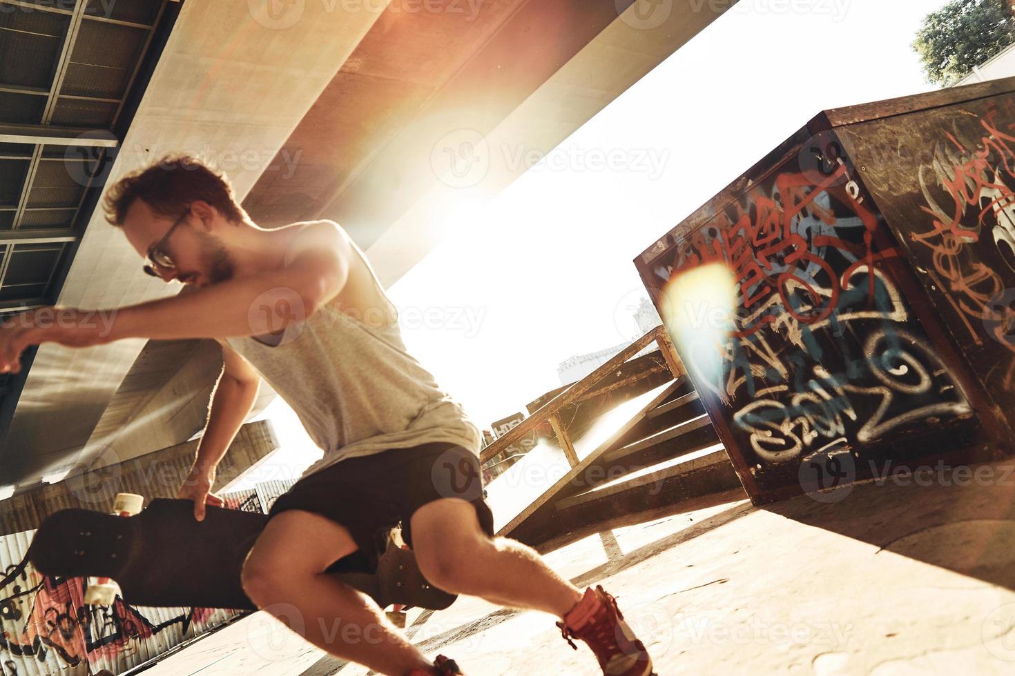 lui è pro. moderno giovane uomo andare con lo skateboard mentre la spesa spensierato tempo a il pattinare parco all'aperto foto