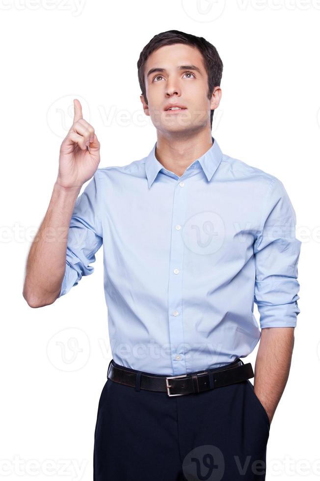 brillante idea riflessivo giovane uomo nel blu camicia Esprimere a gesti e guardare lontano mentre in piedi isolato su bianca foto