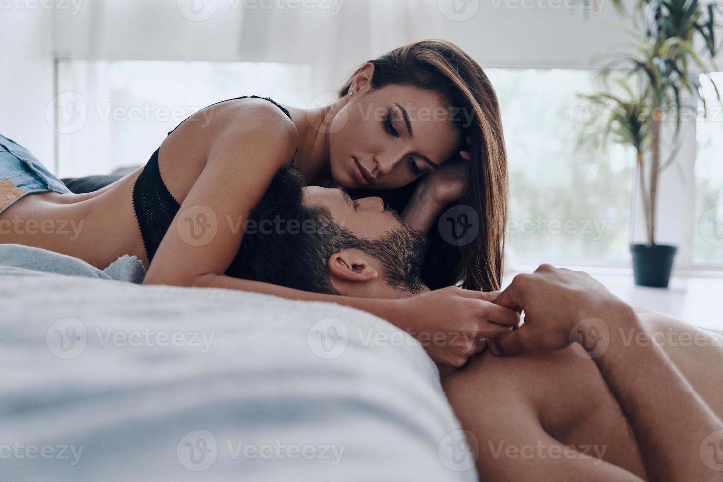 romantico coppia. bellissimo giovane semivestito coppia bonding insieme mentre la spesa tempo nel il Camera da letto foto