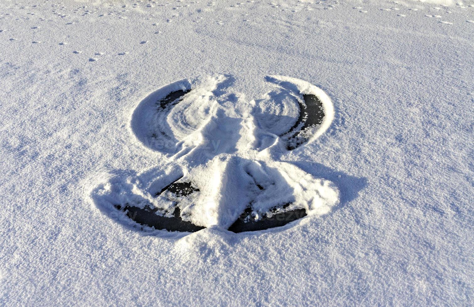 Stampa di un' neve angelo su fresco bianca neve e congelato lago. astratto, inverno divertimento foto