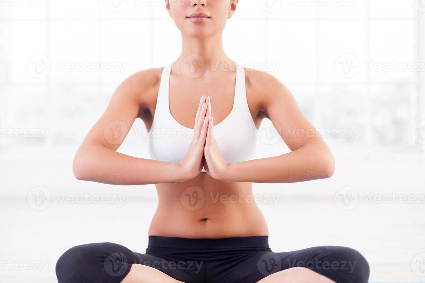 mediazione. ritagliata Immagine di attraente giovane indiano donna mediazione mentre seduta nel loto posizione foto