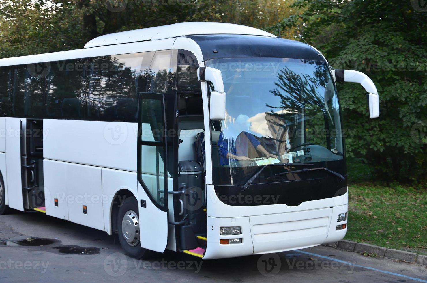 bianca turista autobus per escursioni. il autobus è parcheggiata nel un' parcheggio lotto vicino il parco foto