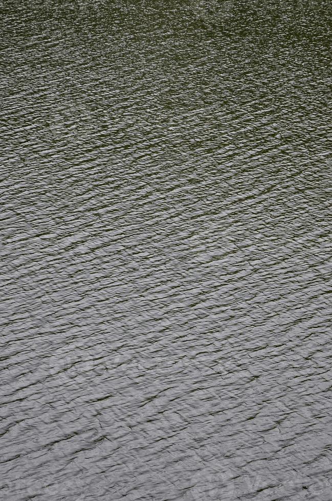 il struttura di buio fiume acqua sotto il influenza di vento, impresso nel prospettiva. verticale Immagine foto