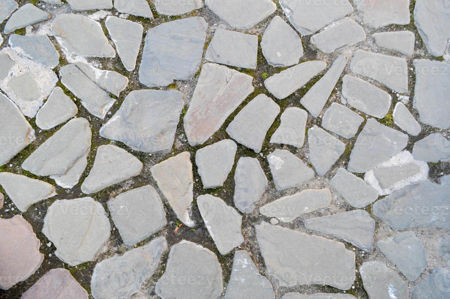 il struttura di il pietra strada, marciapiede, muri di grande grigio vecchio medievale il giro forte pietre, ciottoli. il sfondo foto