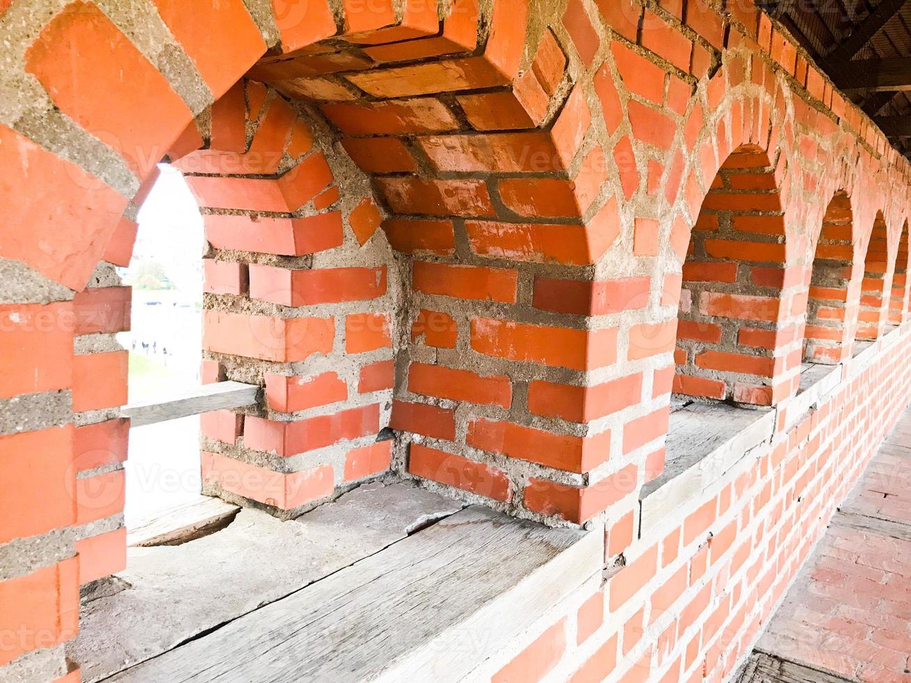 un' piccolo stretto finestra su un vecchio antico pietra di spessore mattone parete nel un vecchio castello. il sfondo foto