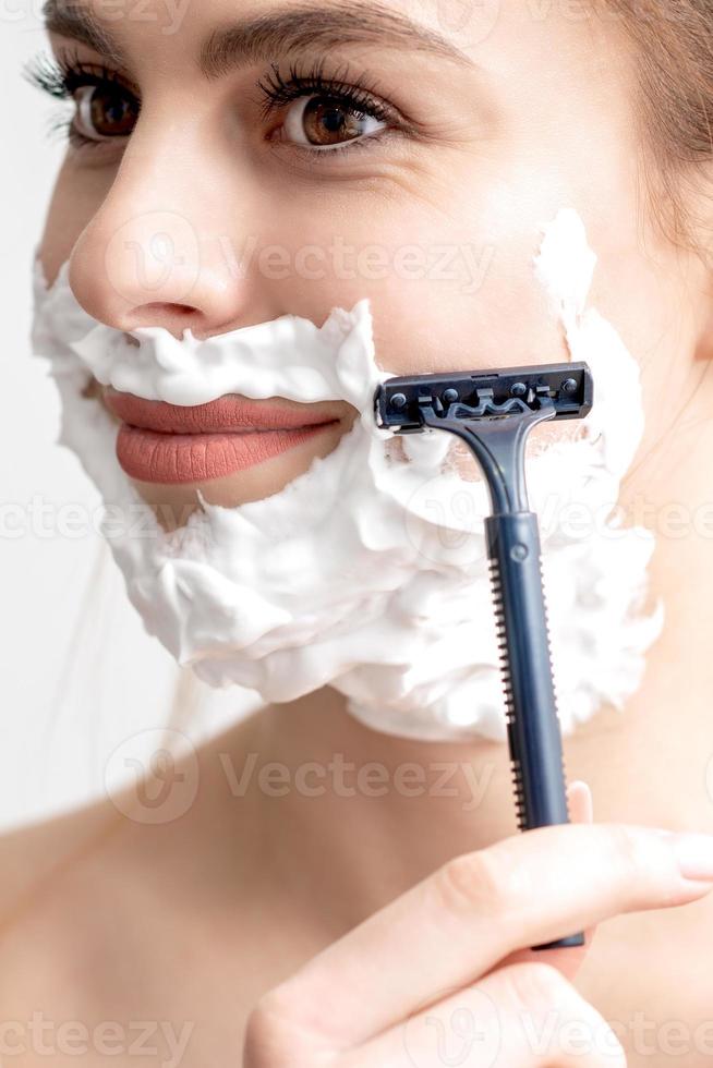 donna rasatura sua viso di rasoio foto
