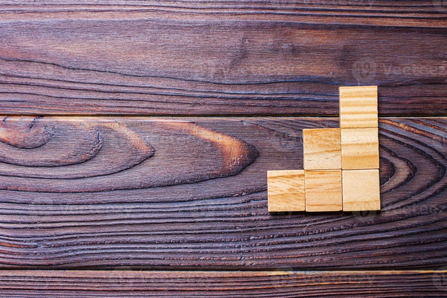 un' di legno blocchi cubo al di sopra di nero di legno strutturato sfondo con copia spazio per Inserisci parola testo titolo. concetto o concettuale legna bloccare scala o tre passi. cubo foto