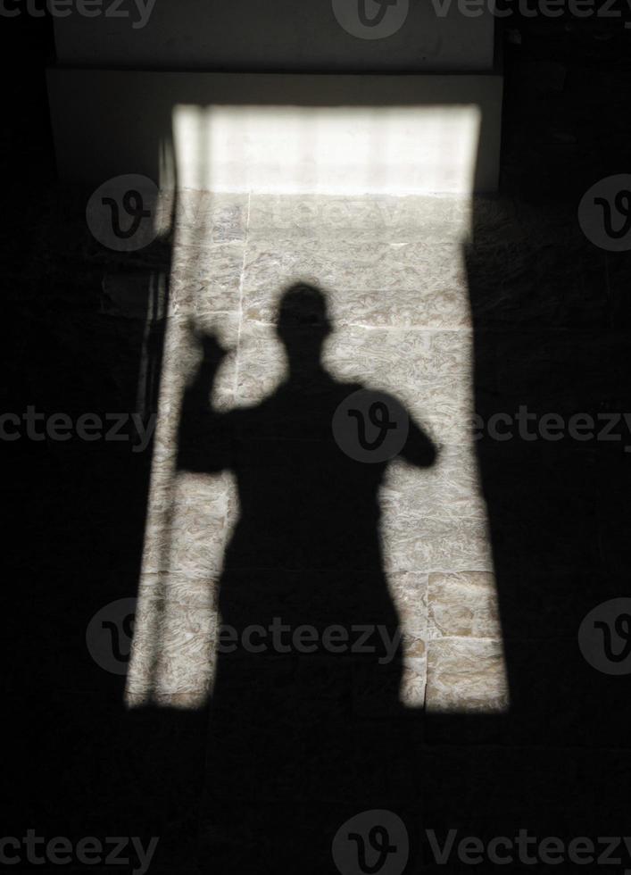 ombra di un' agitando persona nel un' porta telaio foto