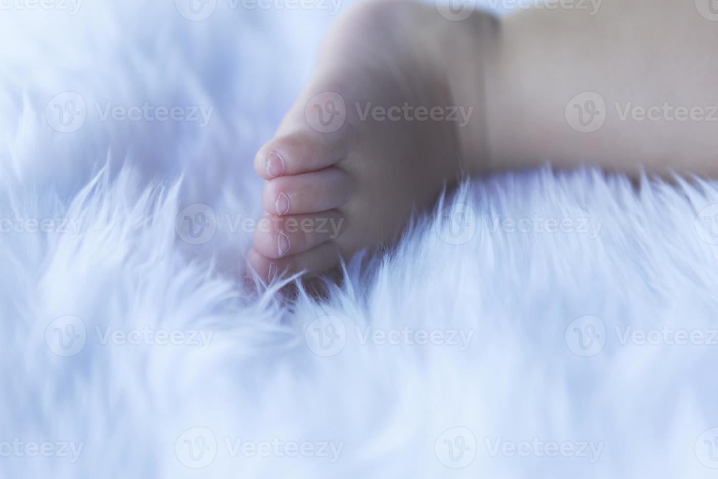 piccolo del bambino piedi su bianca biancheria da letto. foto