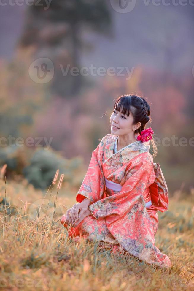 viaggio , vacanza nel Giappone concetto, giovane asiatico donna indossare tradizionale giapponese chimono nel il parco nel il mattina. foto