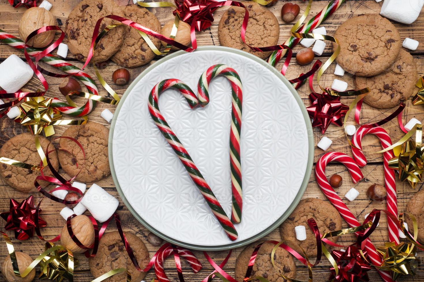 cioccolato patata fritta biscotti Natale canne caramello rosso oro scenario e marshmallow su di legno sfondo vuoto piatto. copia spazio telaio. foto