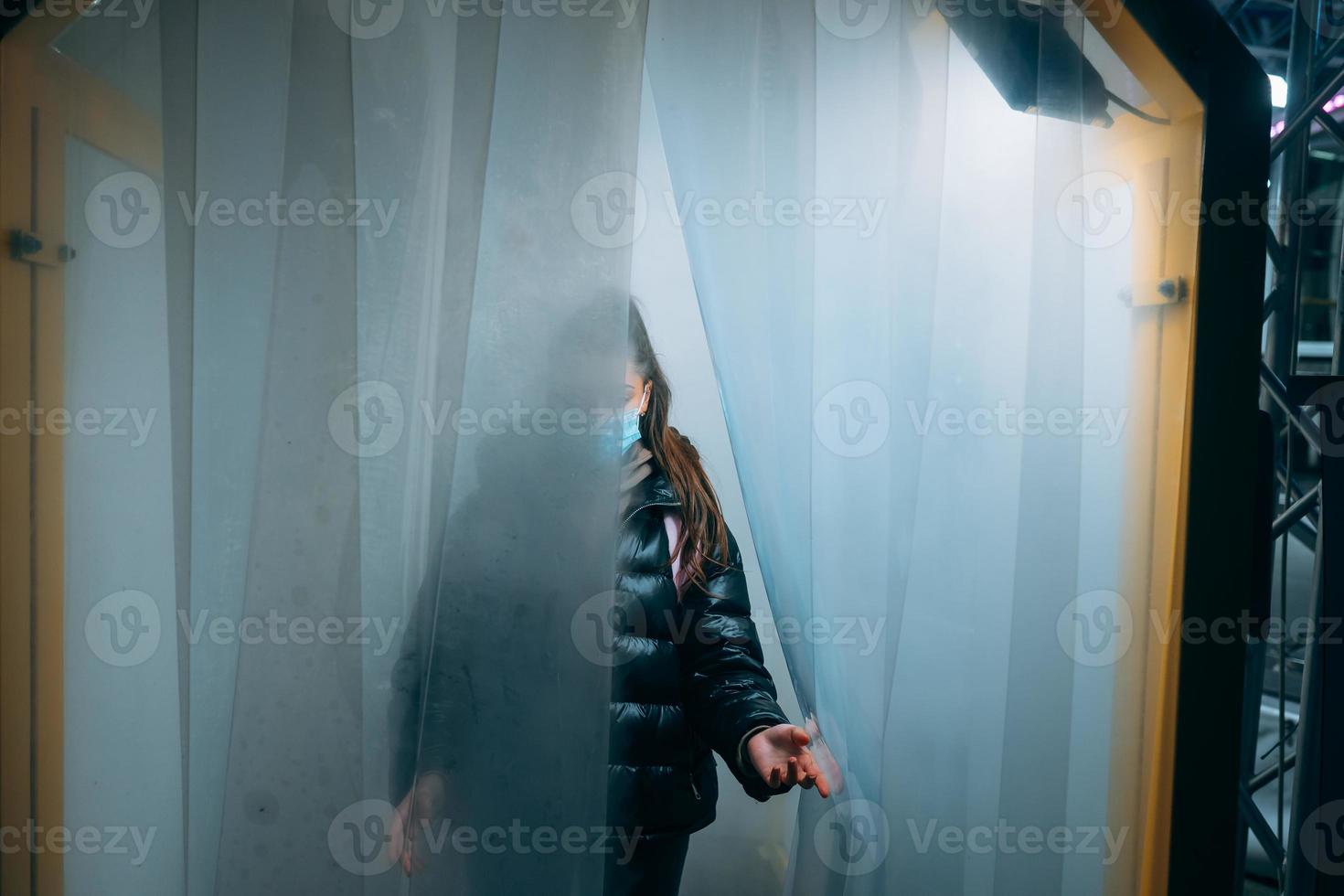 donna a medico maschera è soggiorno nel un' disinfezione tunnel foto