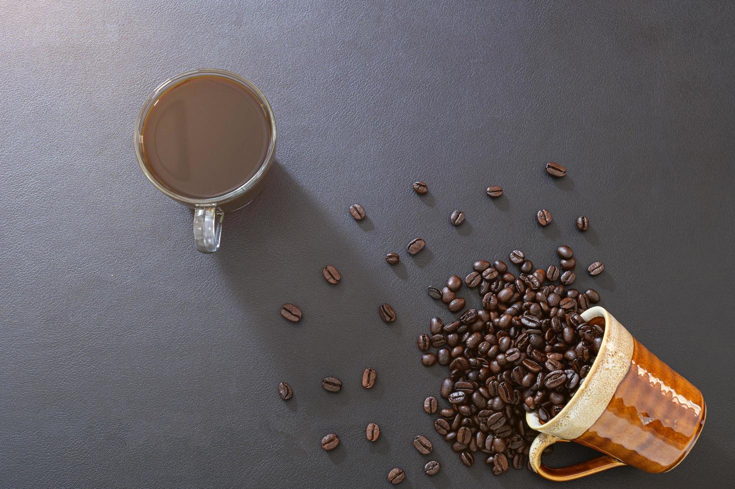 tazze da caffè e chicchi di caffè sulla scrivania foto