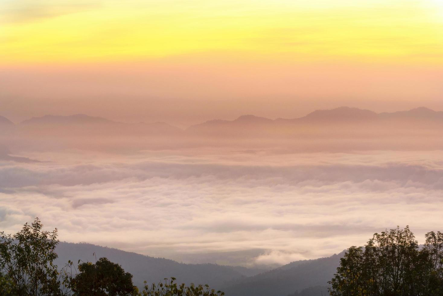 montagne in una nebbia con sole e nuvole foto