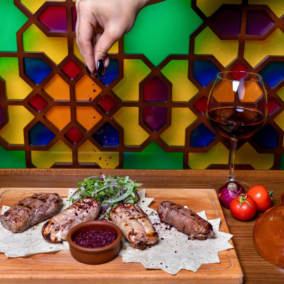 versando chiodi di garofano al kebab di lyulya, farina di carne di pecora foto