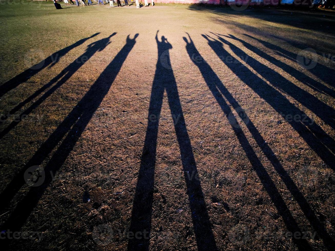 amici la creazione di un' lungo ombre nel il sera su un' scuola campo foto