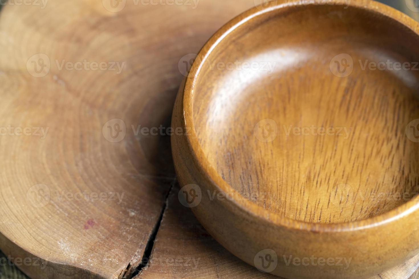 di legno ciotola su di legno tavolo, vuoto il giro ciotola per drogheria e cibo foto