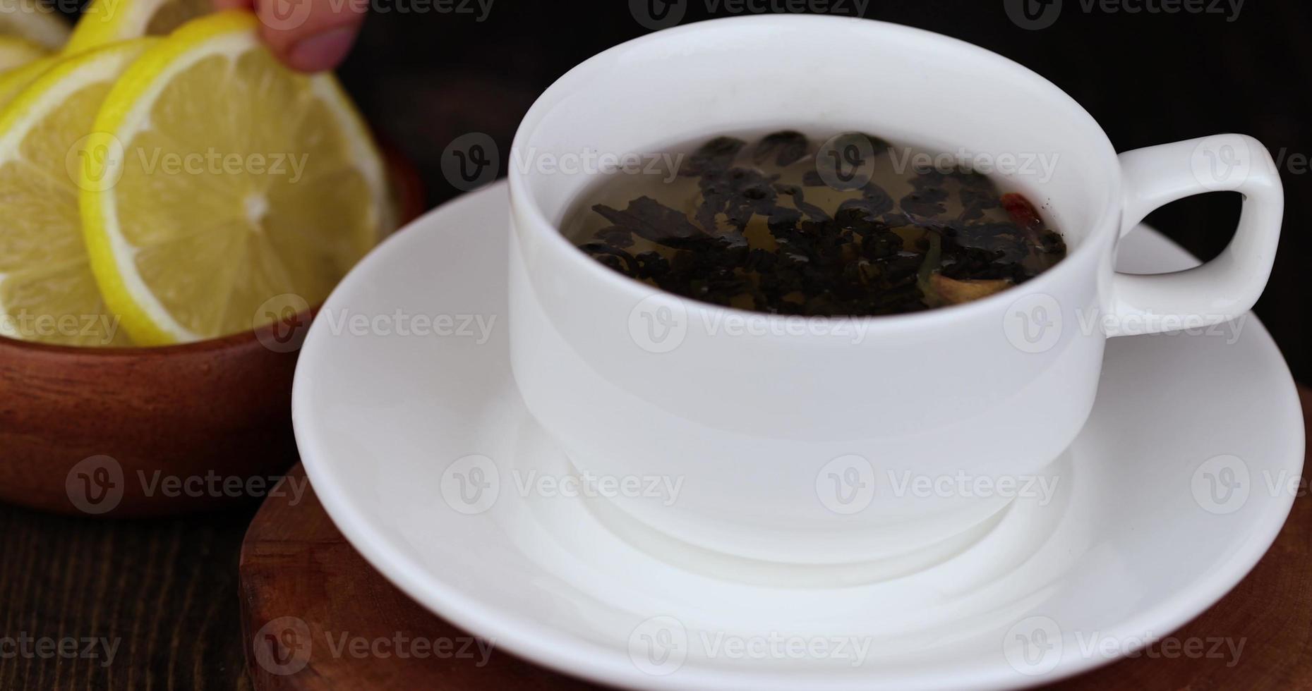 preparare verde tè con Limone nel un' bianca tazza foto