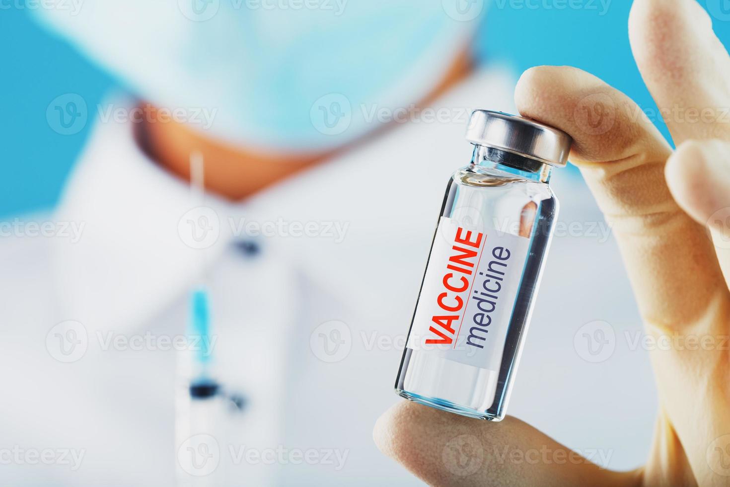 il medico detiene con protettivo guanti e un' maschera detiene il fiala con il vaccino. foto