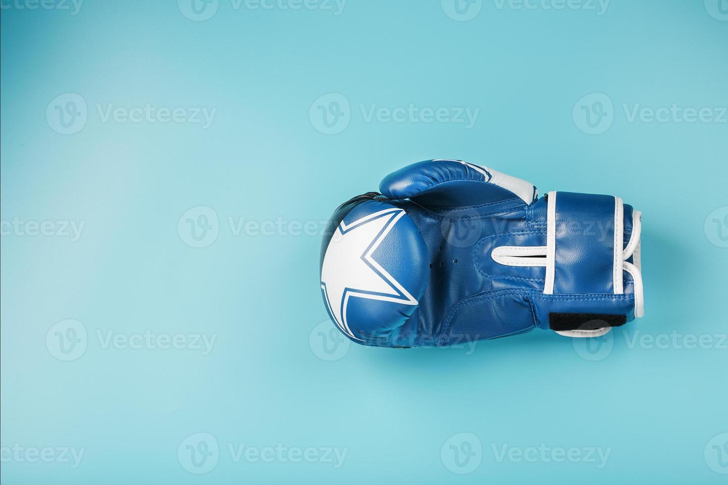 blu boxe guanto su un' blu sfondo con gratuito spazio foto