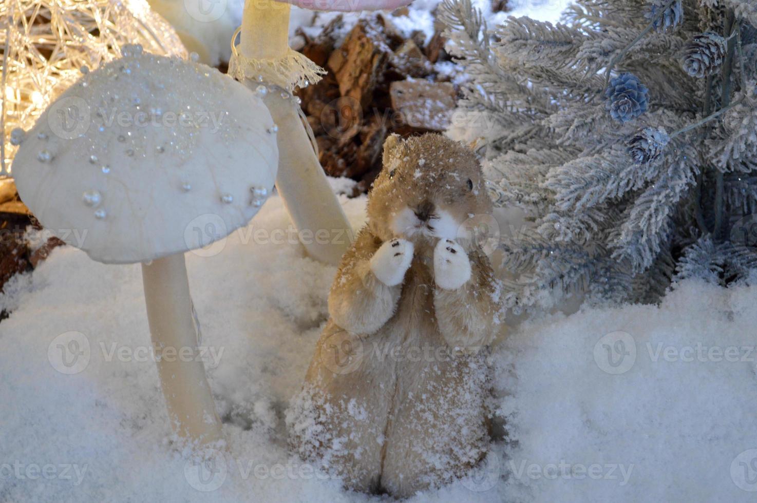 negozio finestra decorazione, shopping centro arredamento. artificiale bianca abete rosso con ghirlande. Il prossimo per loro, un' carino bianca animale è in piedi su Due gambe. peloso furetto gode inverno foto