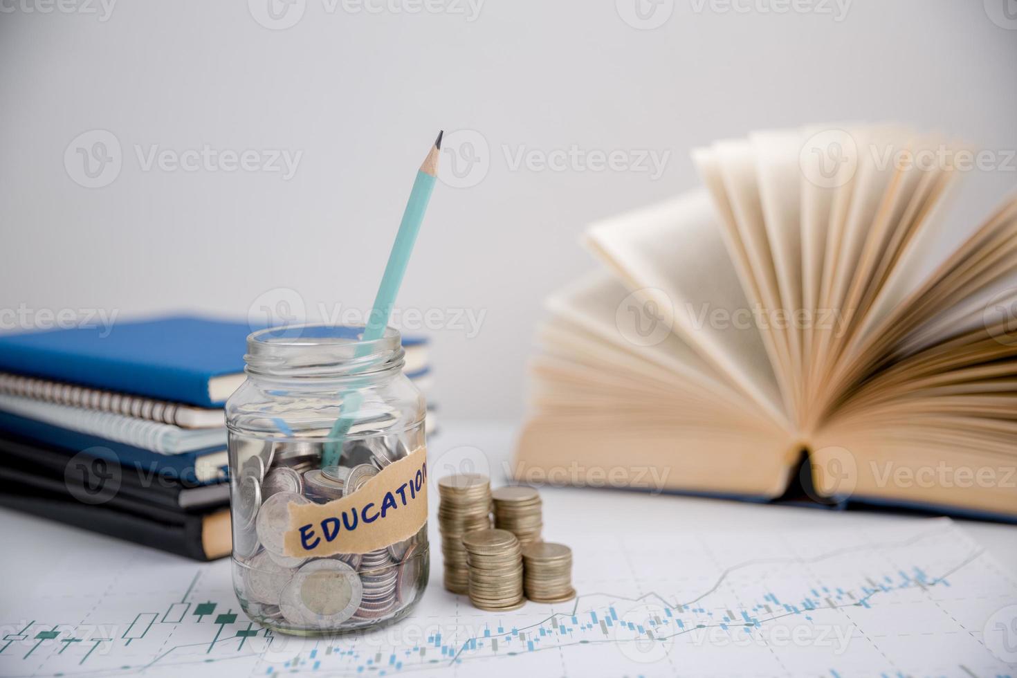 concetto per Salvataggio i soldi reddito per studia, calcolatore alunno finanza costi e investimento bilancio prestito. avvicinamento formazione scolastica oggetto con pila i soldi moneta-contanti dollaro e bicchiere vaso su sfondo. foto