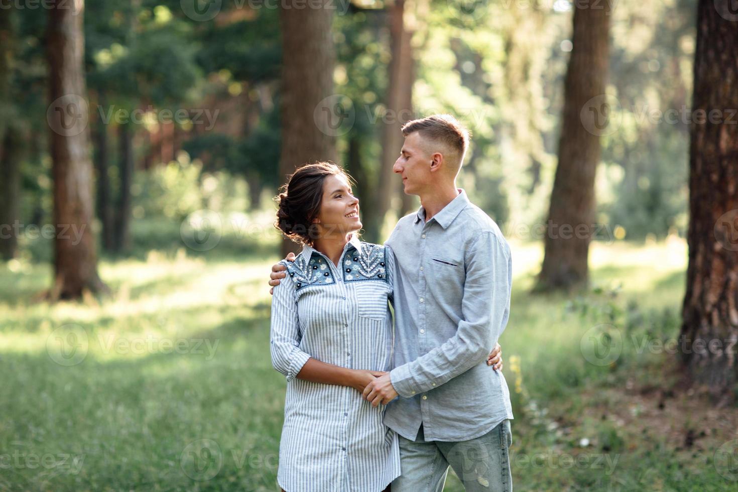 allegro giovane donna e uomo siamo abbracciare all'aperto nel estate parco. incontri e romantico vacanza. coppia nel amore delicatamente guardare a ogni altro su soleggiato giorno. amore e relazioni fra giovane persone foto