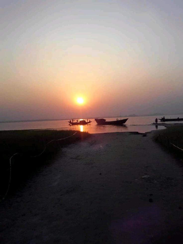 tramonto al di sopra di il fiume foto bianco barca