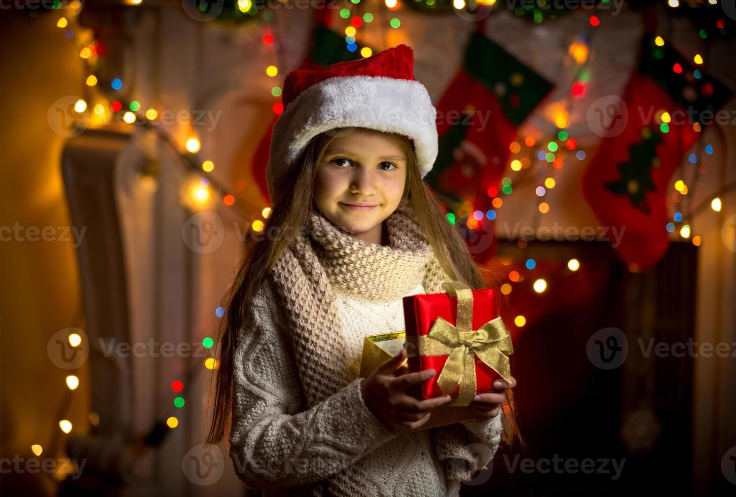 ritratto di ragazza sorridente apertura scintillante confezione regalo a Natale foto