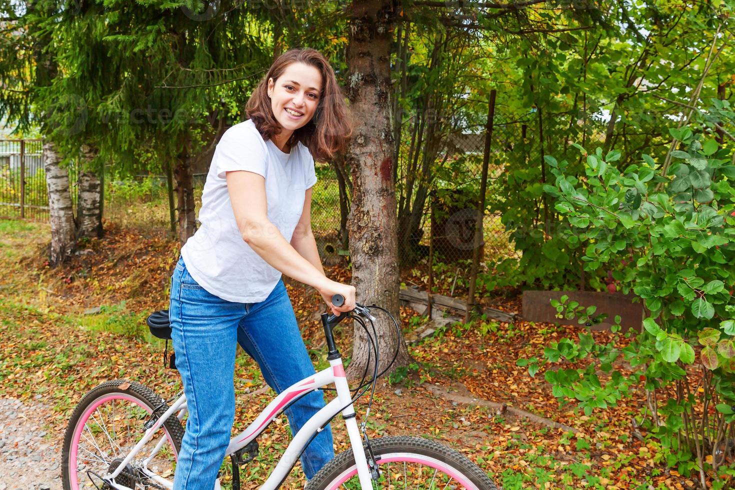 giovane donna equitazione bicicletta nel estate città parco all'aperto. attivo le persone. fricchettone ragazza rilassare e ciclista bicicletta. Ciclismo per opera a estate giorno. bicicletta e ecologia stile di vita concetto. foto