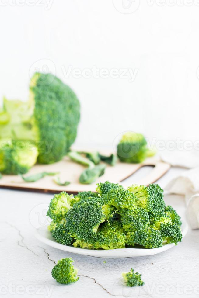 pezzi di crudo broccoli su un' piatto su un' leggero tavolo. foto