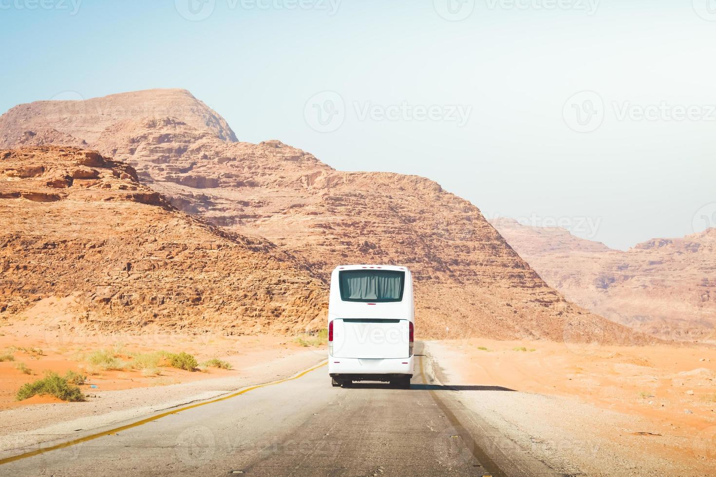 bianca città autobus su asfalto strada nel panoramico montagne sfondo. escursioni e esprimere allenatore servizio aria condizionata nel caldo viaggio destinazioni foto
