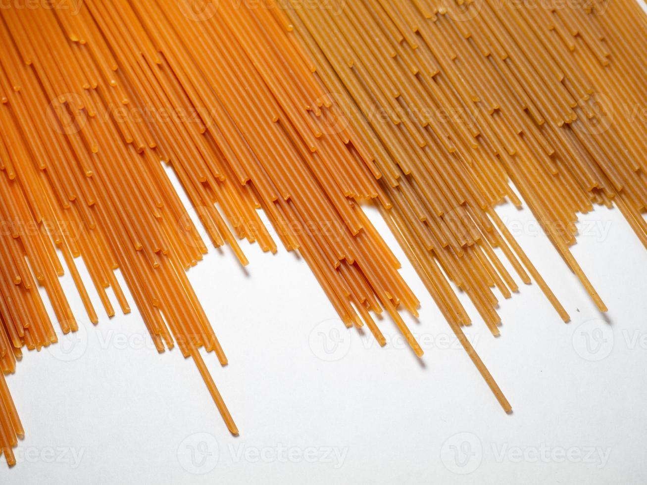 pasta su il tavolo. spaghetti di Due tipi su un' bianca sfondo. pomodoro e grano saraceno pasta. italiano cibo. cucina di il popoli di il mondo. cucinando cibo. foto