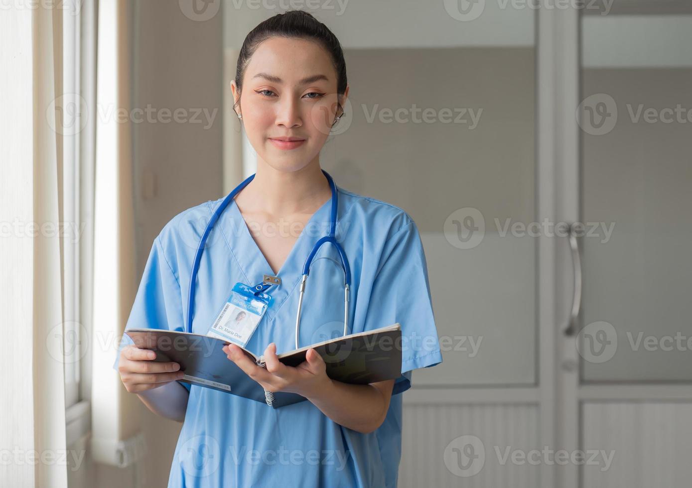 donna medico persona indossa uniforme e stetoscopio lettura documento di paziente informazione per chirurgia consultazione. asiatico femmina professionale infermiera è Lavorando come assistenza sanitaria consultazione nel ospedale foto