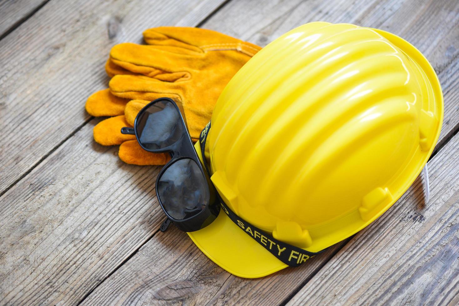 sicurezza attrezzatura standard costruzione sicurezza industriale protettivo abbigliamento da lavoro attrezzo con giallo cappello sicurezza casco bicchieri e guanti su legna sfondo foto