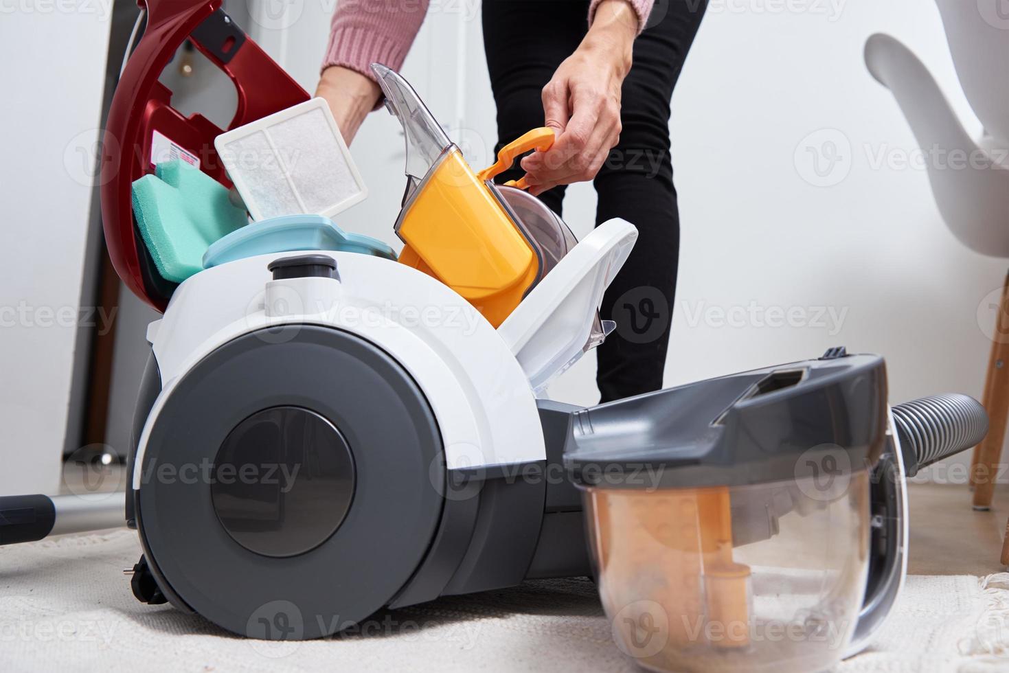 donna prende su contenitore di polvere a partire dal vuoto addetto alle pulizie foto