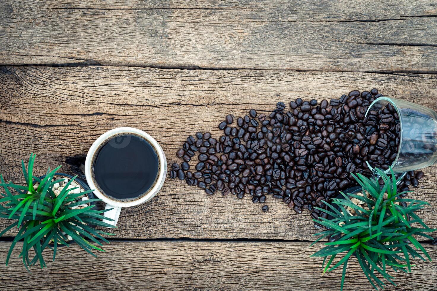 tazza di caffè e chicchi di caffè sulla scrivania, vista dall'alto foto