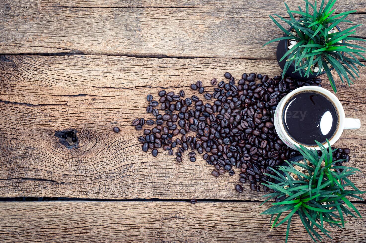 tazza di caffè e chicchi di caffè sulla scrivania foto