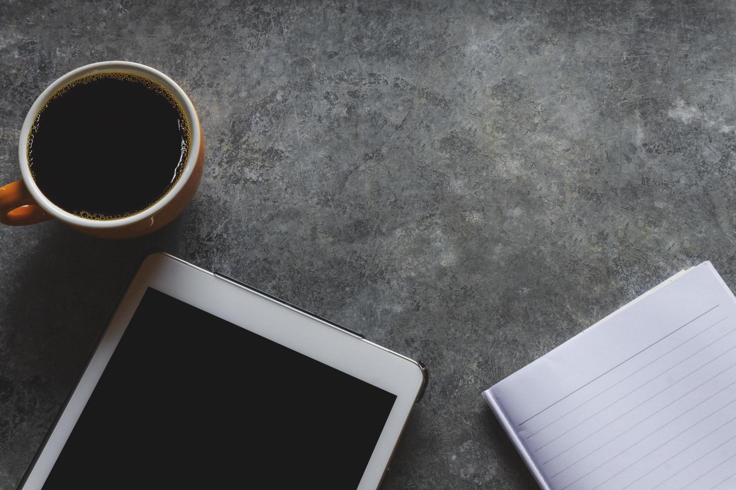 tazza di caffè e tablet sul tavolo foto