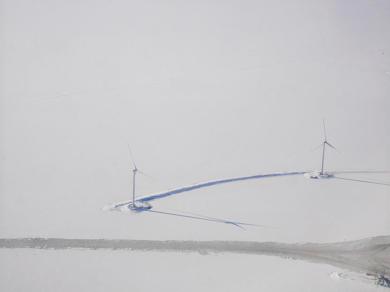 aereo Visualizza di bianca neve copertura città e moderno vento turbina nel inverno, snowscape sfondo, città nel bianca, Scandinavia, artico cerchio foto