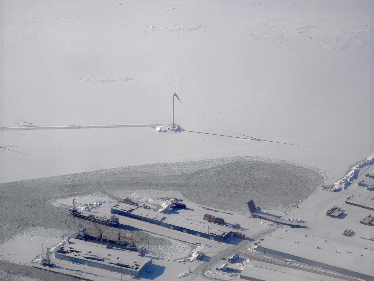 aereo Visualizza di bianca neve copertura città e moderno vento turbina nel inverno, snowscape sfondo, città nel bianca, Scandinavia, artico cerchio foto
