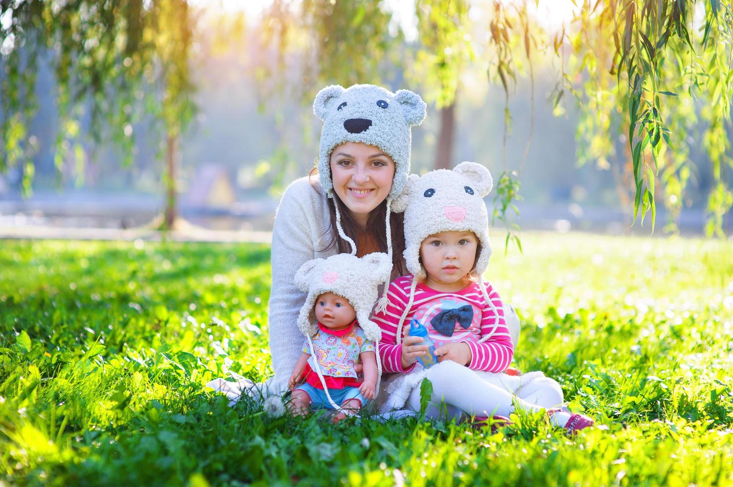 mamma e figlia che giocano nel parco con una bambola foto