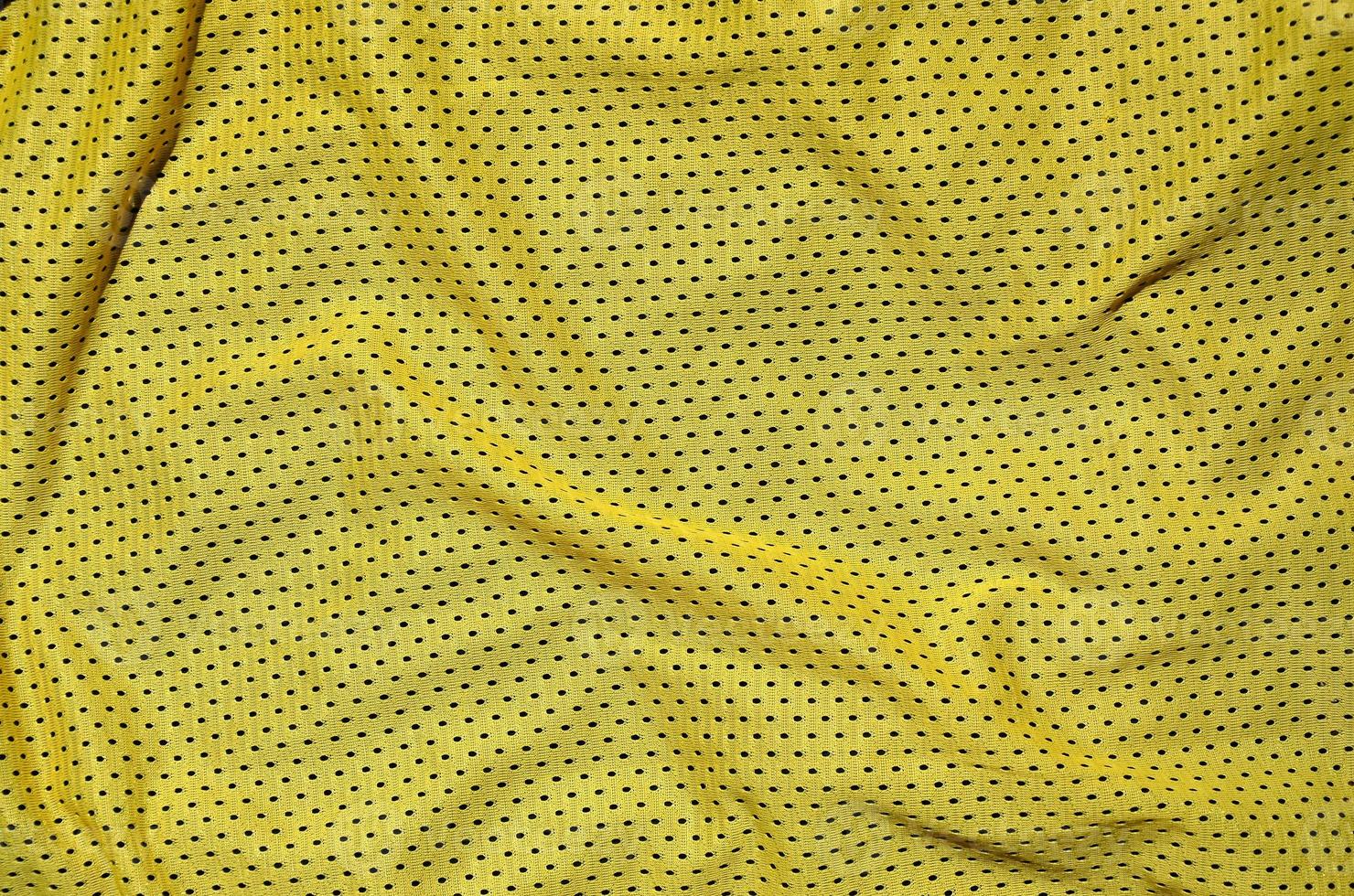 vicino su di giallo poliestere nylon abbigliamento sportivo pantaloncini per creato un' strutturato sfondo foto